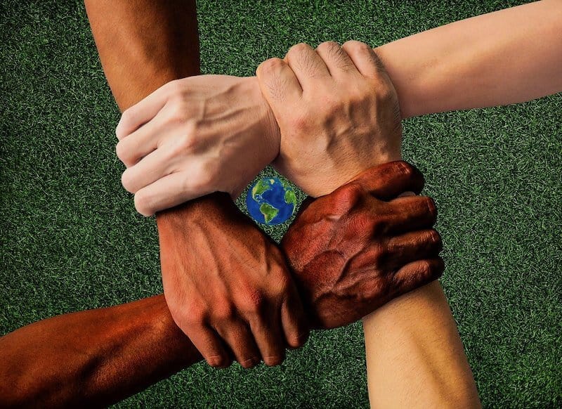 Verschiedene Hautfarben mit einer Welt in der Mitte