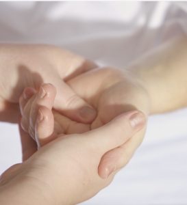 Therapeut hält Hand einer Patientin