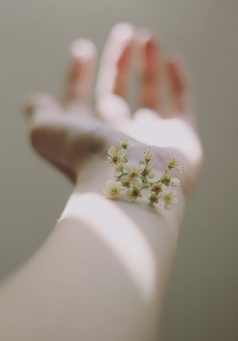 Hand mit Blume auf dem Handgelenk